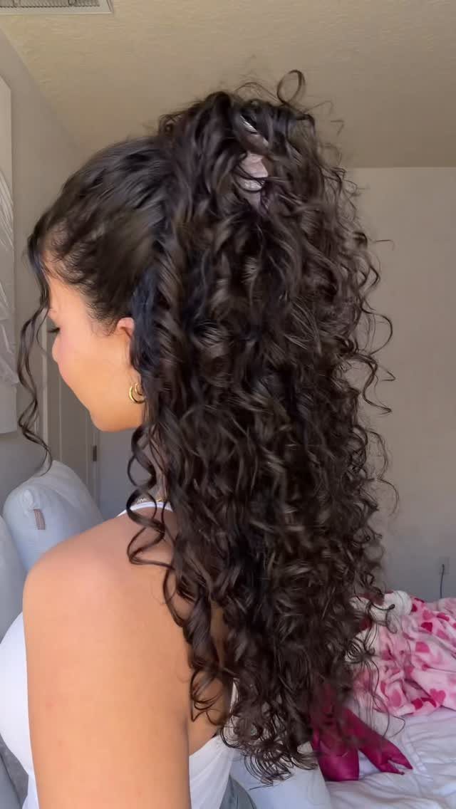 2C Curly Hairstyles: 10 Ideas for Layers, Buns and Bangs 7 Woman with long dark curly hair styled in a high ponytail from the side