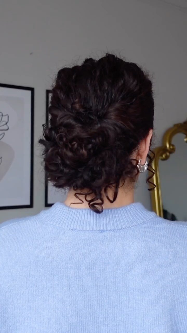 2C Curly Hairstyles: 10 Ideas for Layers, Buns and Bangs 4 Dark curly hair styled in a low messy bun from the back view.