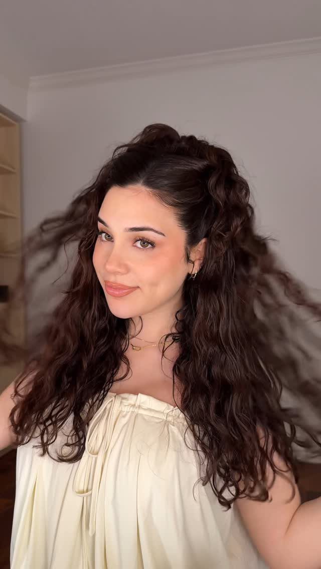 2C Curly Hairstyles: 10 Ideas for Layers, Buns and Bangs 9 Woman with long dark brown curly hair wearing a cream off-the-shoulder top.