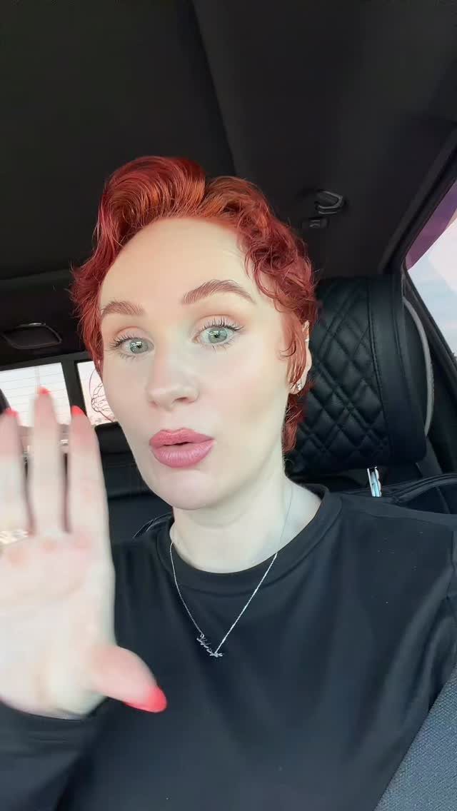 2C Curly Hairstyles: 10 Ideas for Layers, Buns and Bangs 6 Woman with short curly red hair posing inside a car with black seats.