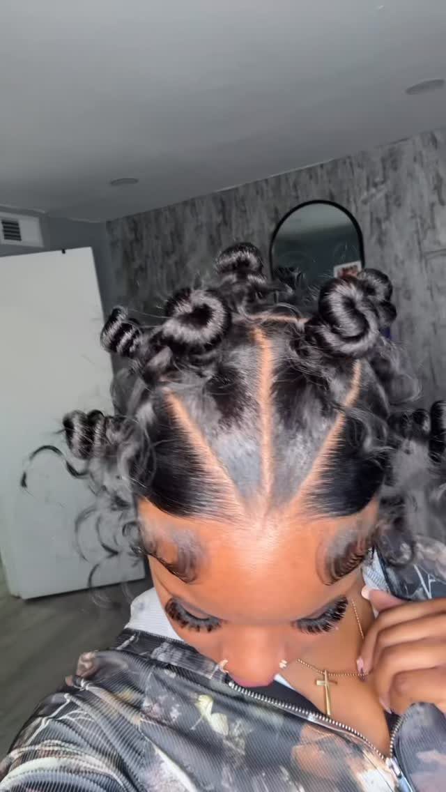 Woman with black hair styled in small Bantu knots across her head.