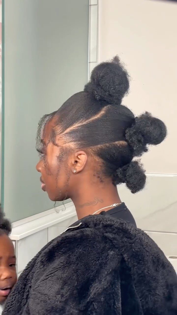 Woman with natural hair styled in three small puffs along her head.