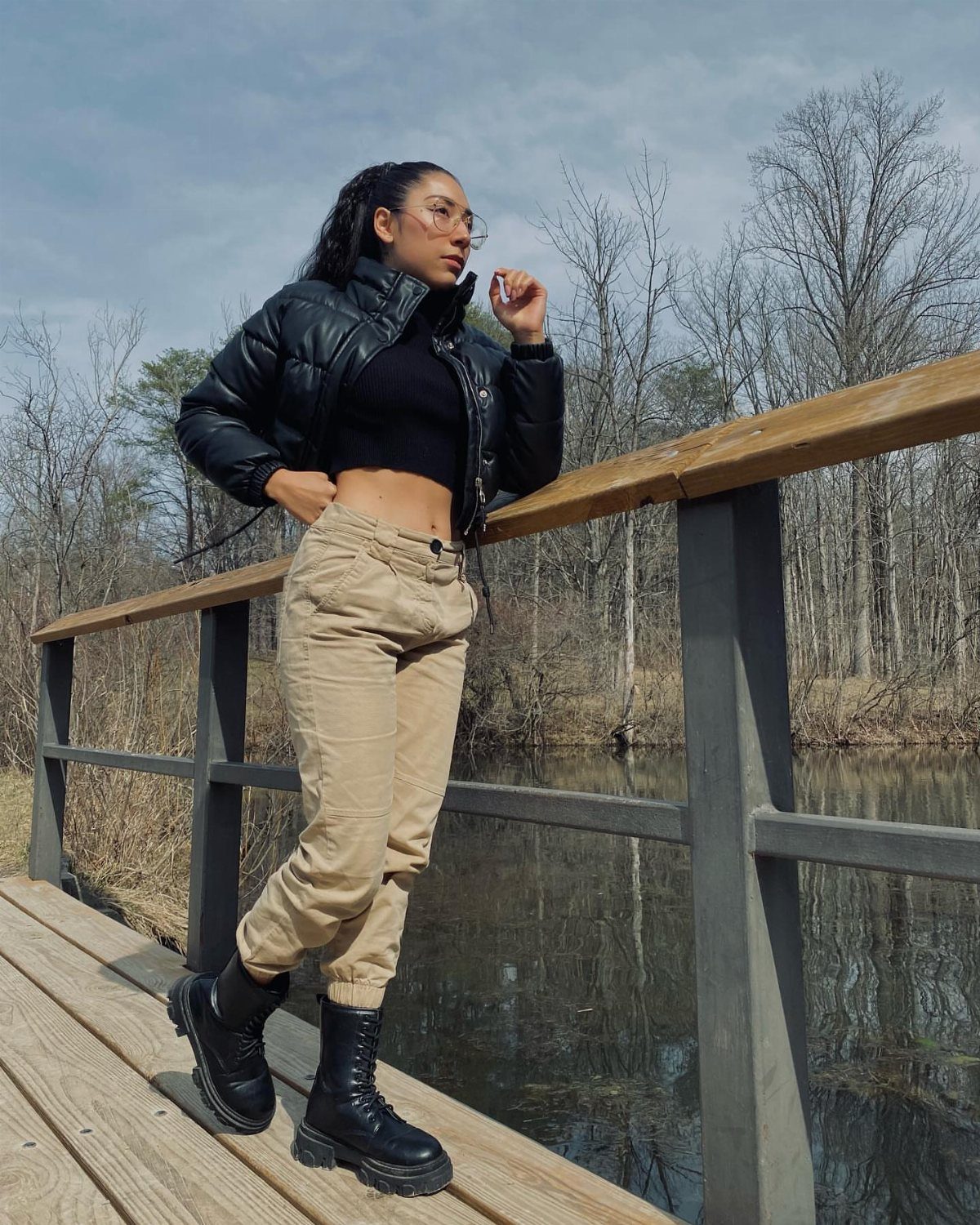 57 Degree Weather Outfit: 19 Ideas to Wear Now 11 Woman in tan cargo pants and black combat boots posing on wooden bridge.