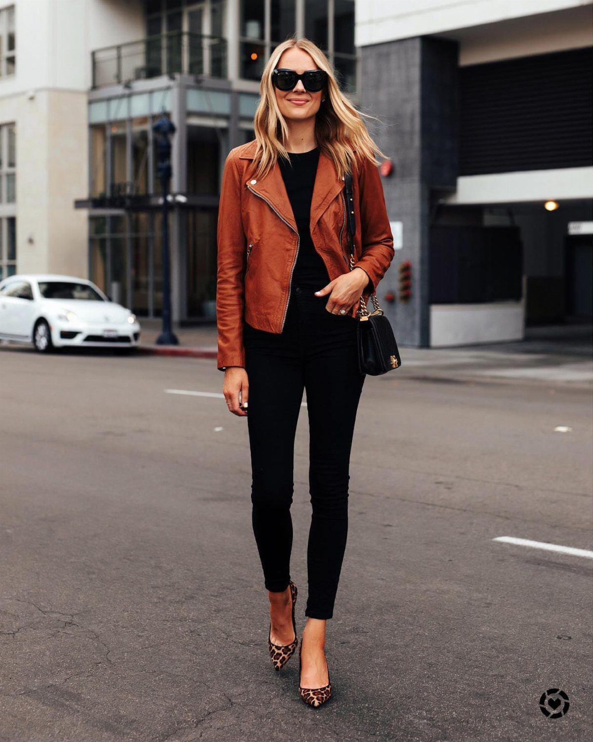 57 Degree Weather Outfit: 19 Ideas to Wear Now 5 Woman wearing a brown leather jacket, black pants, and leopard print heels on street.