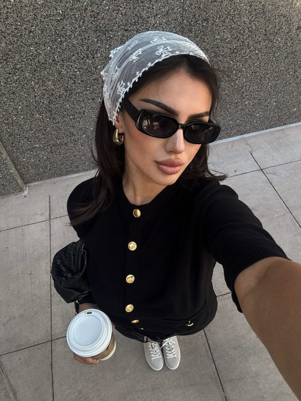 57 Degree Weather Outfit: 19 Ideas to Wear Now 13 Woman wearing a black structured cardigan with gold buttons and a white lace headscarf.