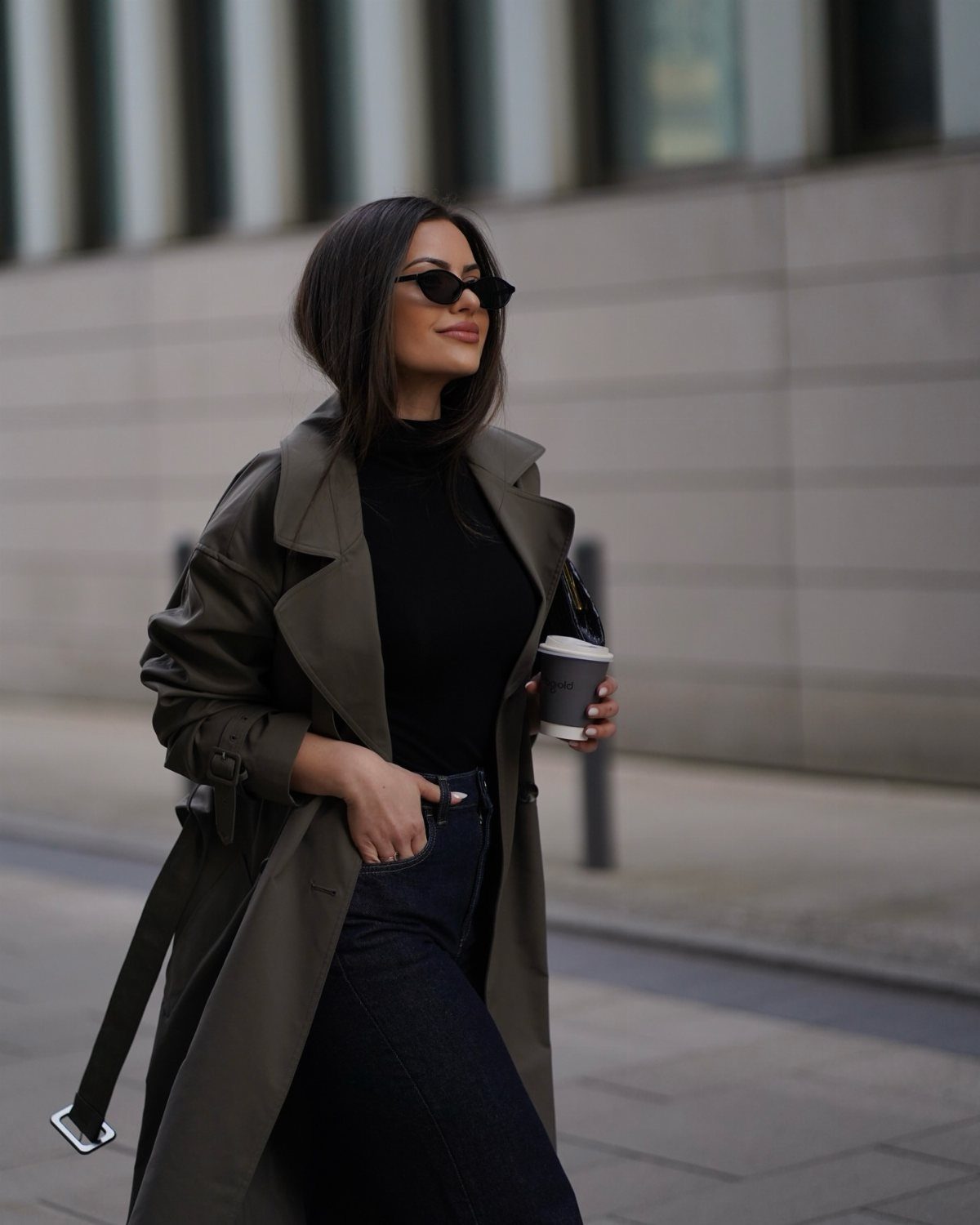 57 Degree Weather Outfit: 19 Ideas to Wear Now 2 Woman wearing an olive green trench coat, black turtleneck, and dark blue jeans.