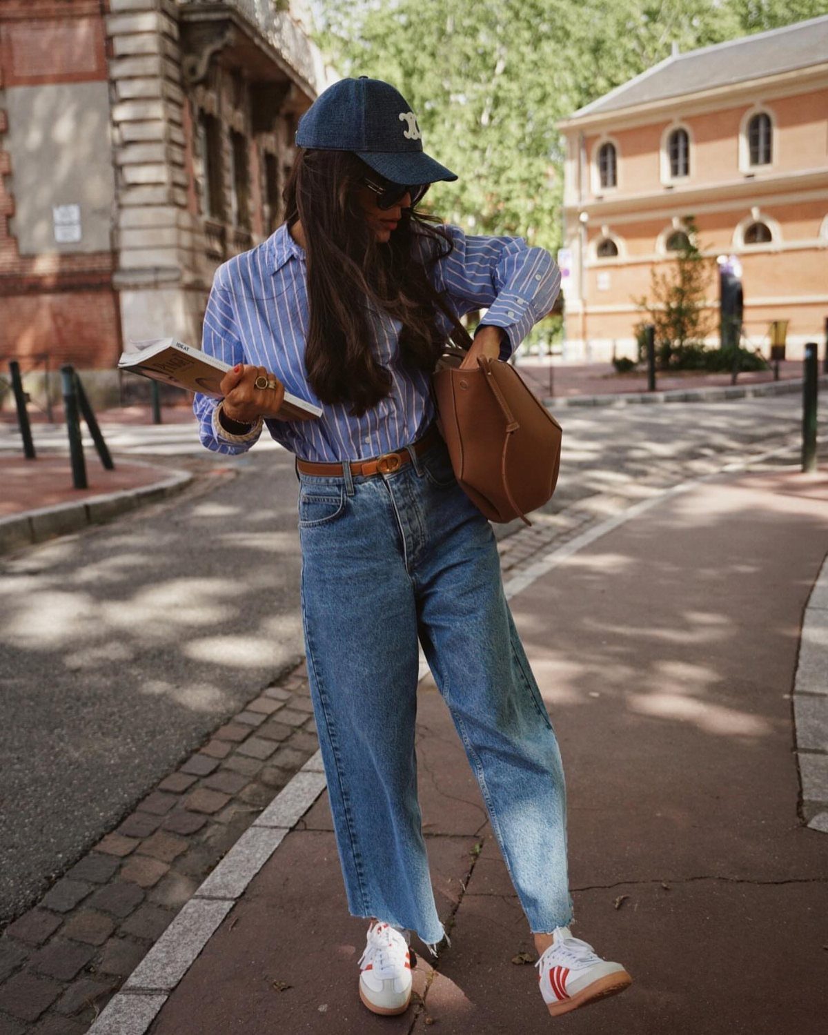Adidas Outfit Shoes for 5 Casual and Dressed-Up Looks 3 Woman wearing wide-leg blue jeans and white Adidas sneakers on a city street
