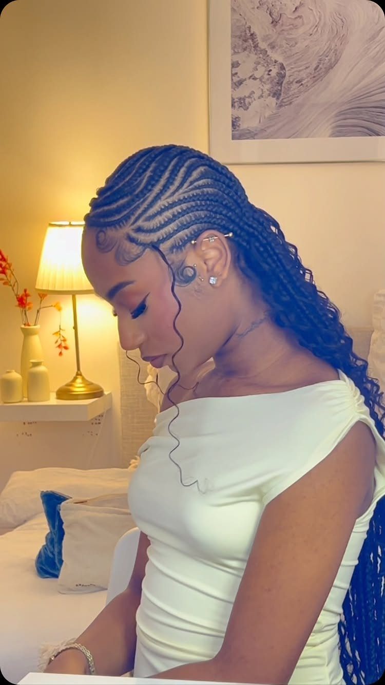 African Hair Lines: 10 Cornrow and Braid Styles to Wear 9 Woman with thick curved cornrow braids wearing a white off-the-shoulder dress.