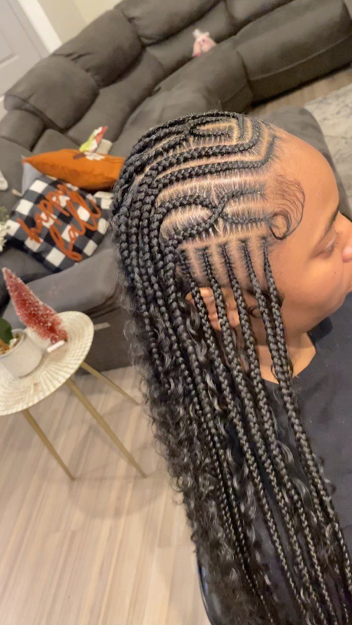 African Hair Lines: 10 Cornrow and Braid Styles to Wear 7 Intricate curved cornrows and long hanging braids on a person's head.