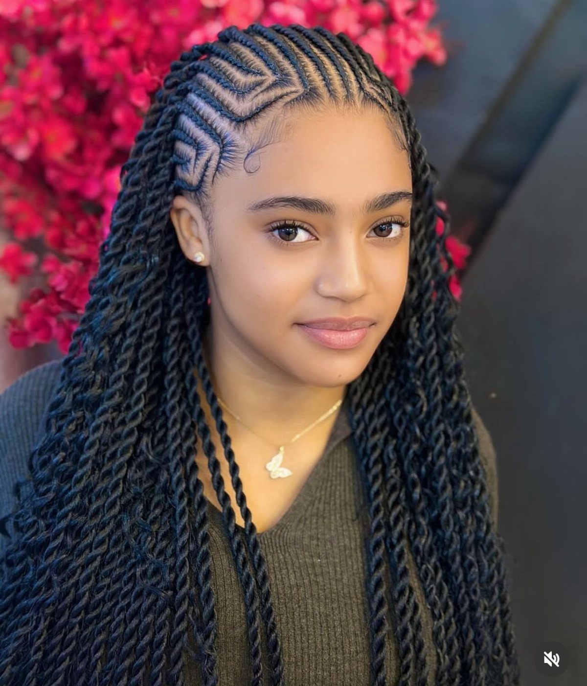 African Hair Lines: 10 Cornrow and Braid Styles to Wear 5 Woman with geometric cornrow patterns and long black twisted braids against pink flowers