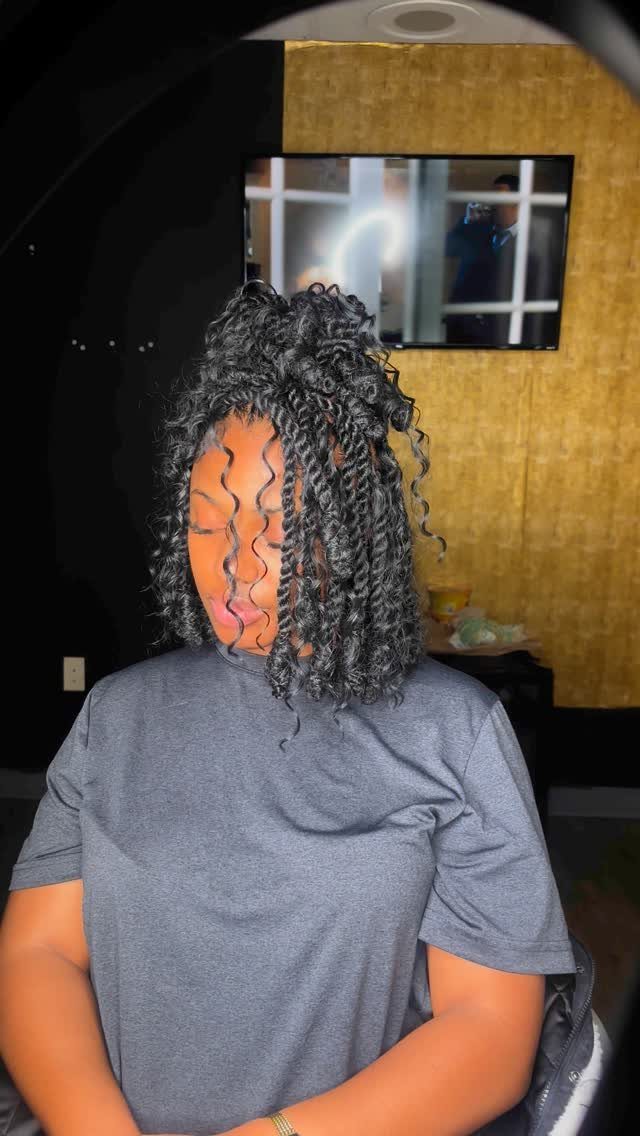 Woman with dark curly hair styled in a half-up ponytail and loose curls.