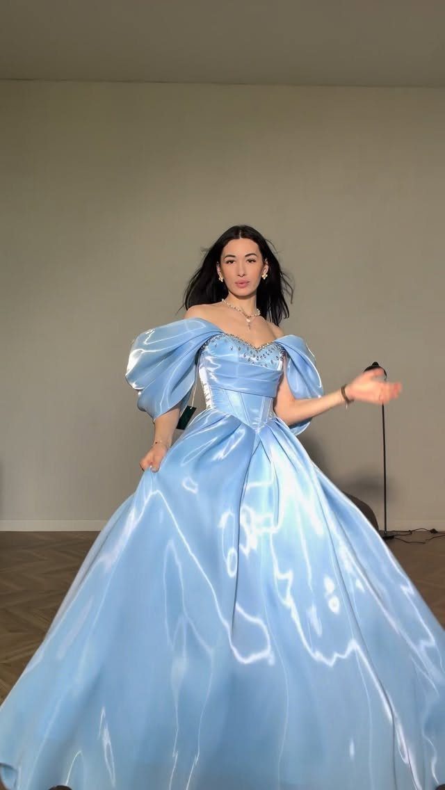 Ball Dresses Blue for Prom and Formal Events: 10 Ideas 8 Woman in a light blue satin ball gown with puff sleeves and full skirt.