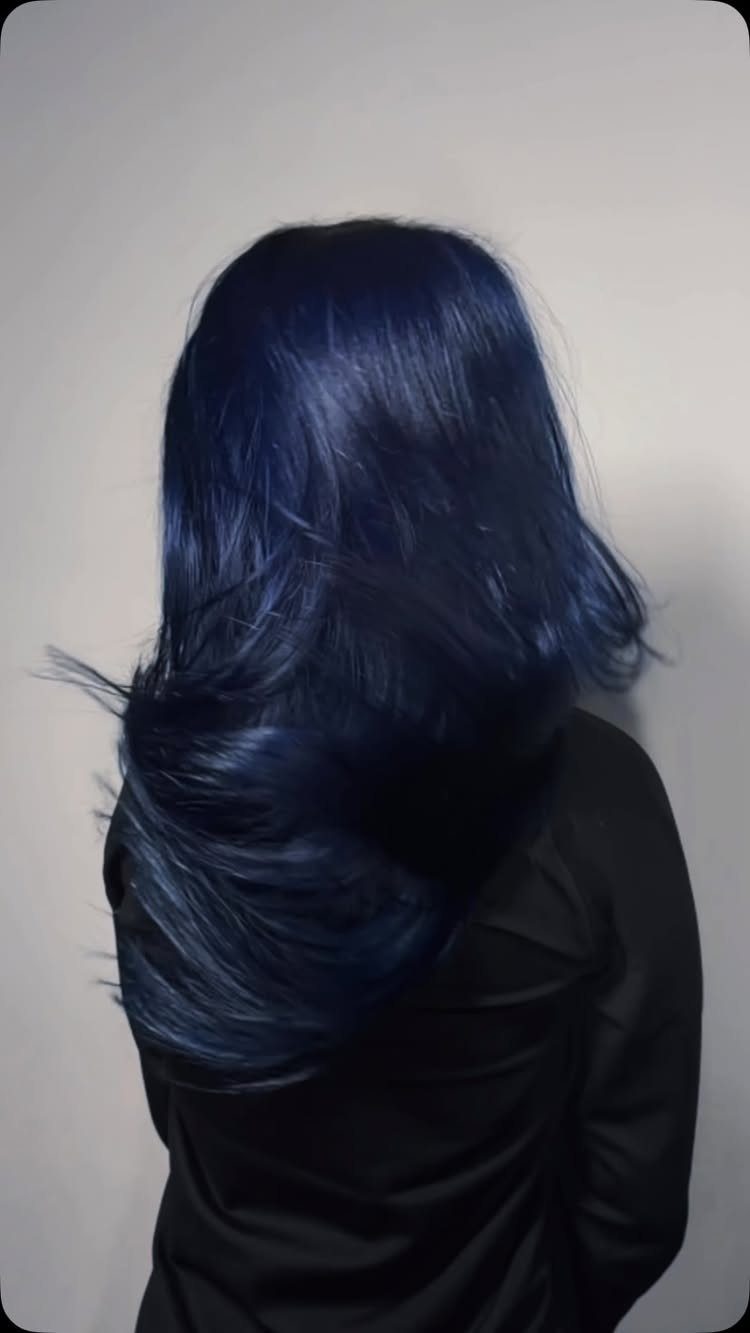Best Hair Dye for Dark Hair: 8 Shades and Ideas 7 Long wavy midnight blue hair on a person wearing a black shirt.
