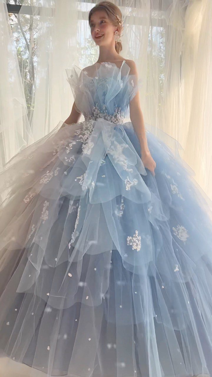 Big Princess Dress Ideas: 7 Tulle, Lace and Satin Gowns 1 Woman in a voluminous light blue tulle gown with floral embroidery and tiered skirt.