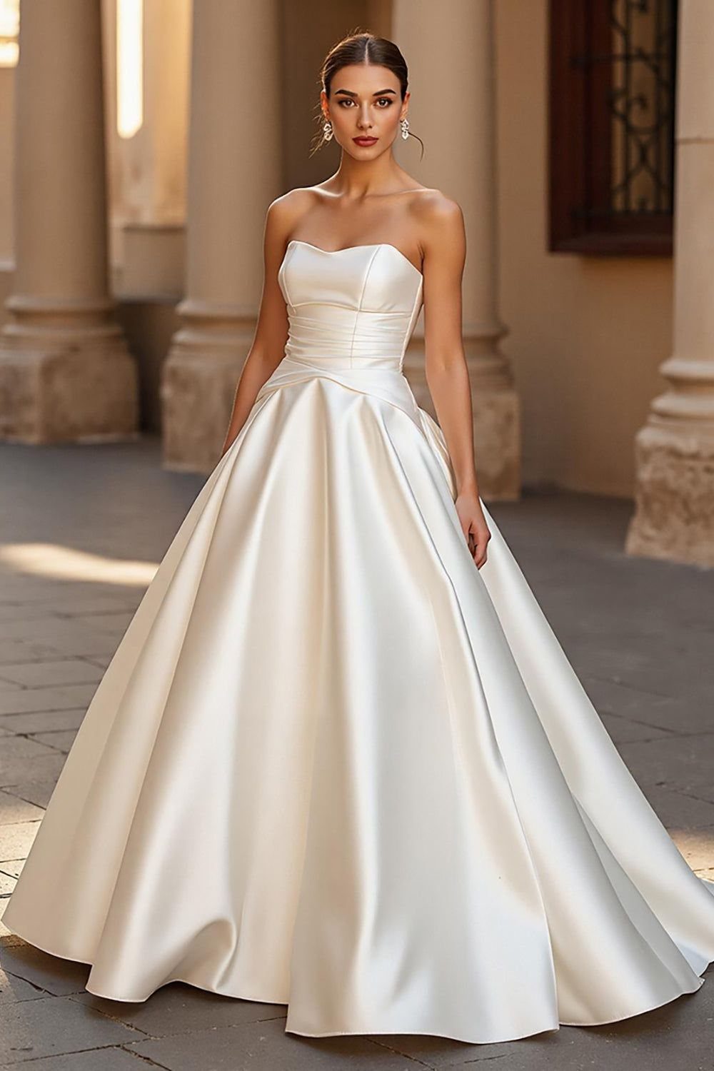 Big Princess Dress Ideas: 7 Tulle, Lace and Satin Gowns 7 Woman in a strapless white satin ball gown standing in a stone courtyard