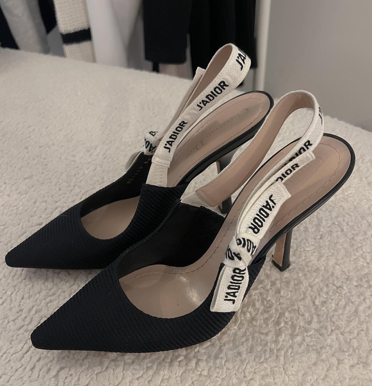 Black J'Adior slingback pumps with white embroidered straps on a white surface