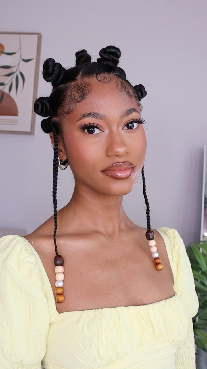 17 Black Natural Hair Ideas for Every Length and Style 7 Woman with Bantu knots and beaded braids wearing a yellow top.