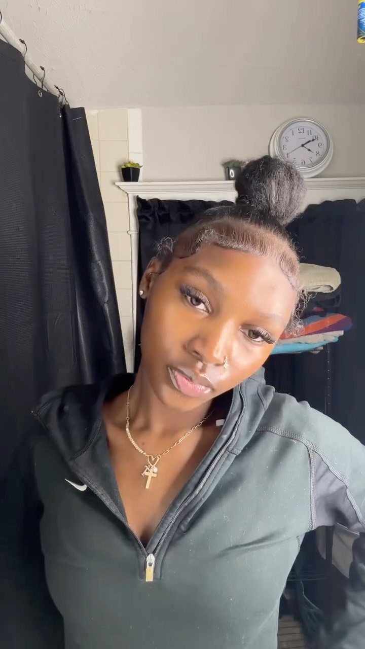 17 Black Natural Hair Ideas for Every Length and Style 3 Young Black woman with a high natural hair bun and gold cross necklace.