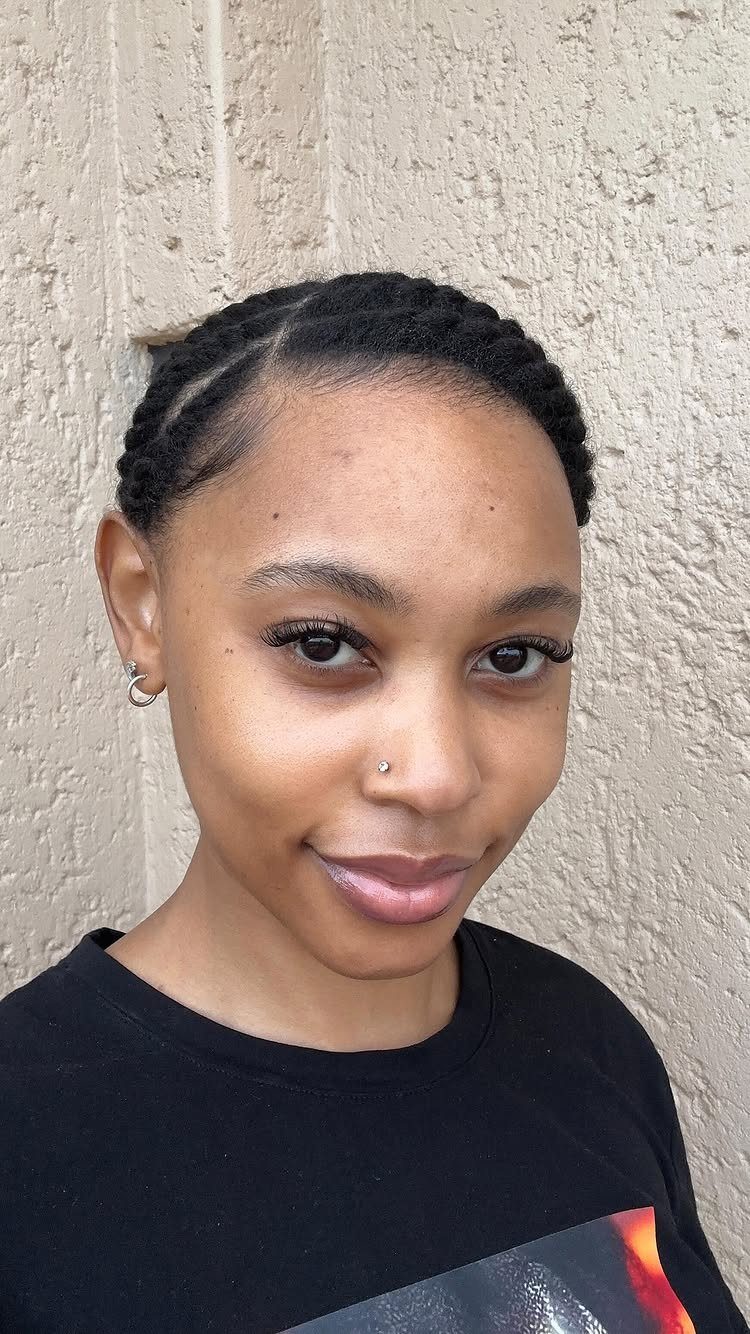 17 Black Natural Hair Ideas for Every Length and Style 9 Black woman with flat twist hairstyle posing against a textured beige wall