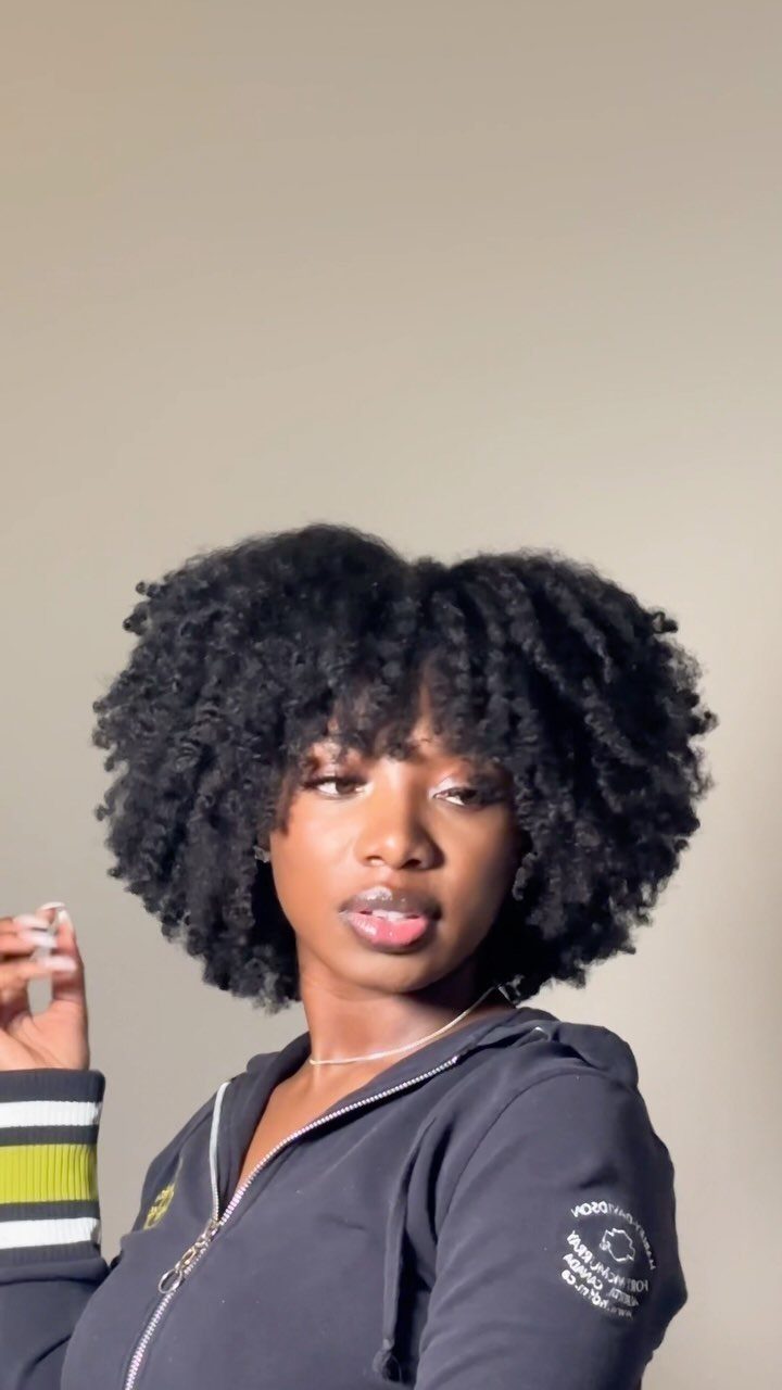 17 Black Natural Hair Ideas for Every Length and Style 17 Woman with voluminous, curly black natural hair in a fluffy twist-out hairstyle.
