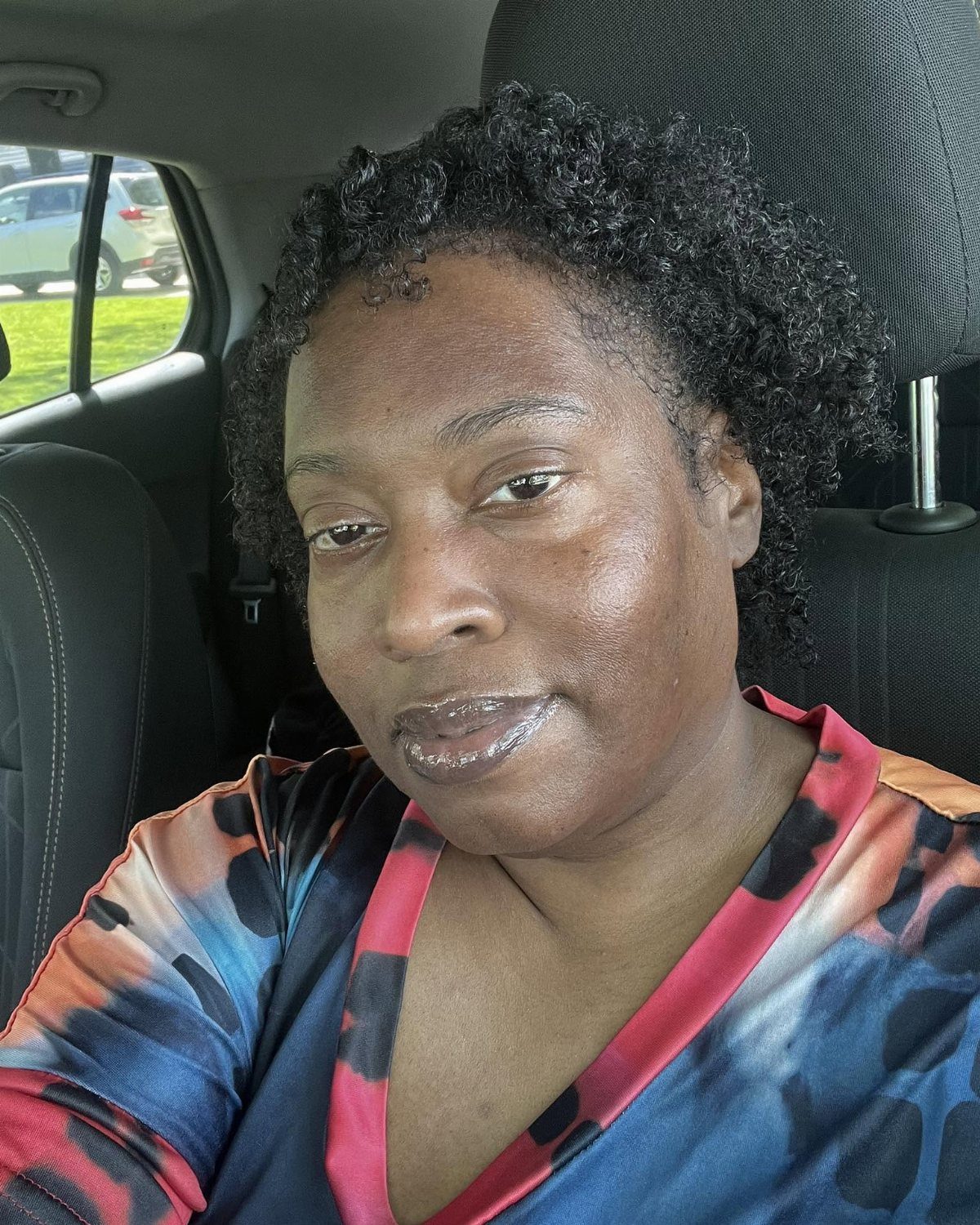 17 Black Natural Hair Ideas for Every Length and Style 8 Woman with a short, curly natural mini afro hairstyle sitting in a car.