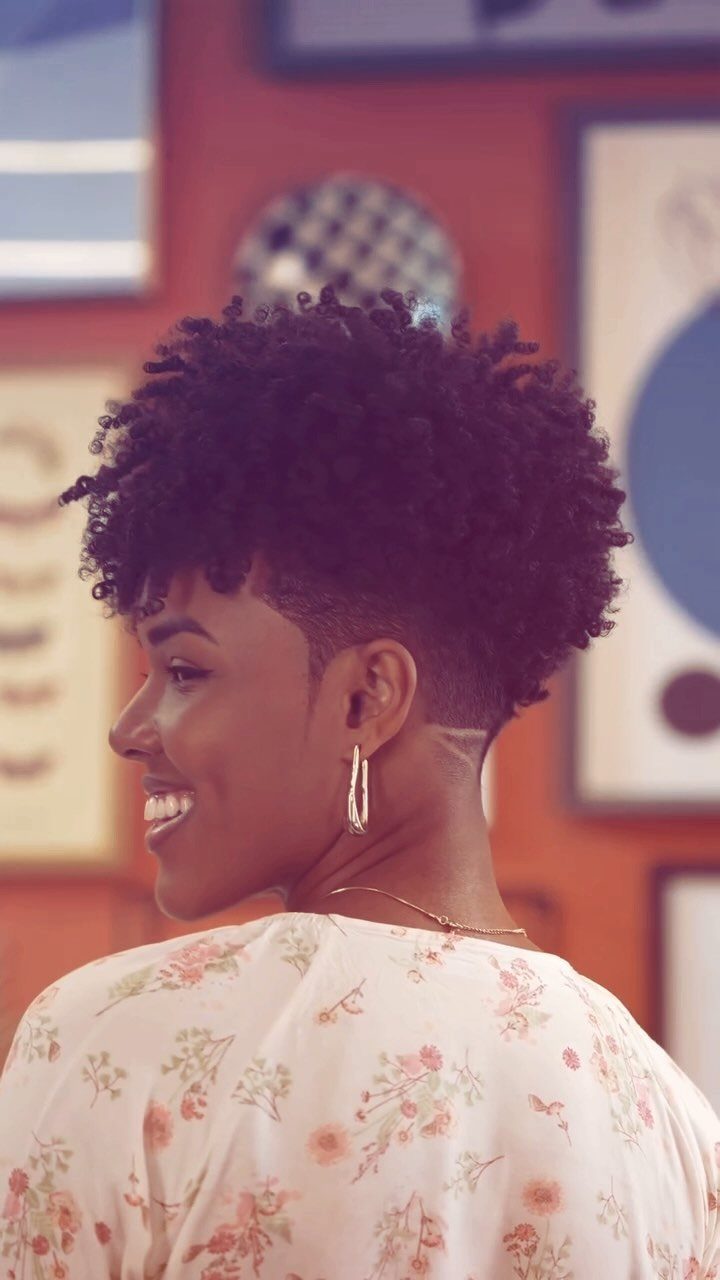 17 Black Natural Hair Ideas for Every Length and Style 11 Black woman with a tapered natural haircut and curly afro in profile view.