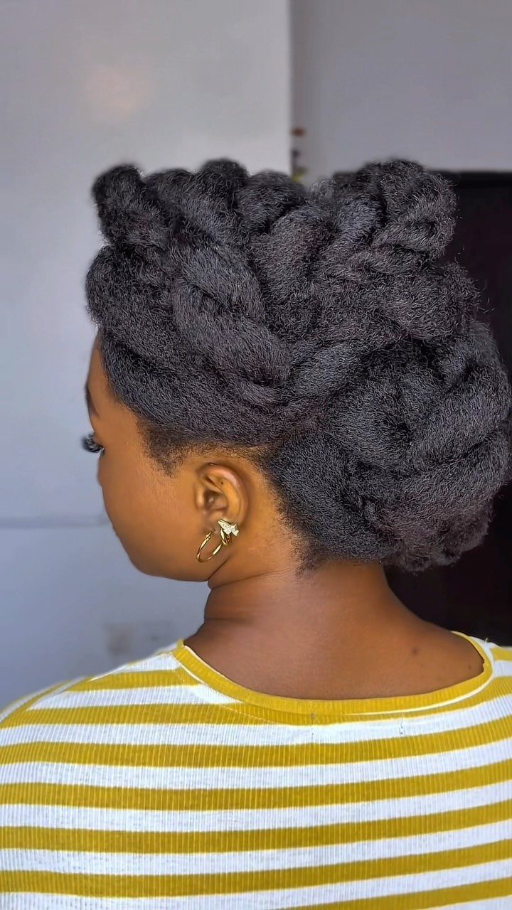 17 Black Natural Hair Ideas for Every Length and Style 4 Woman with black natural hair styled in a voluminous, textured updo hairstyle.