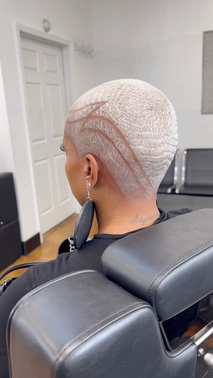 17 Black Natural Hair Ideas for Every Length and Style 12 Person with short bleached blonde natural hair featuring shaved lines and wave patterns.