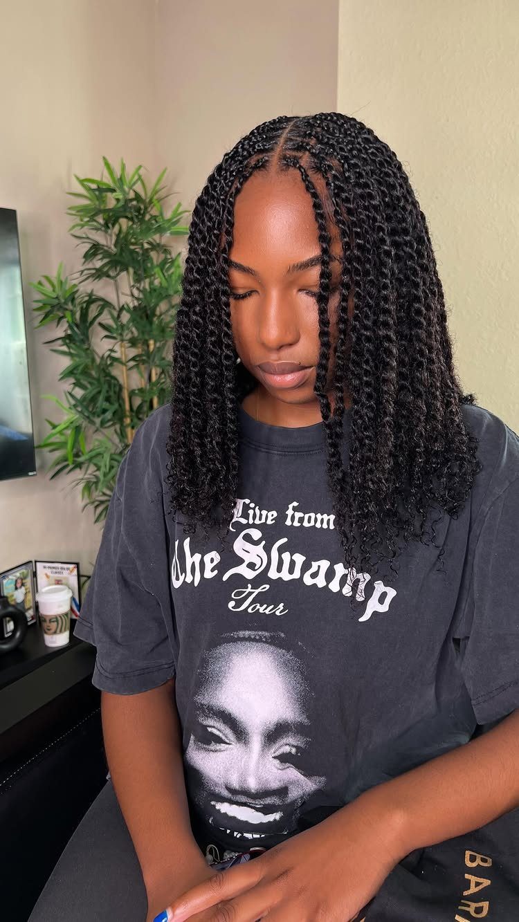 17 Black Natural Hair Ideas for Every Length and Style 13 Black woman with long two-strand twists wearing a black graphic t-shirt indoors.