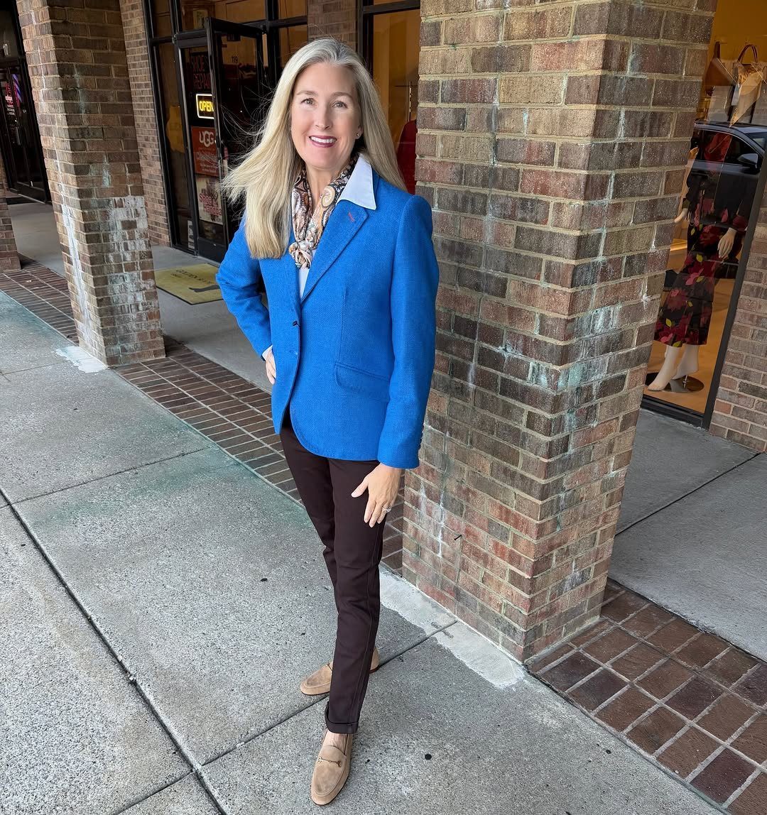 Blue Blazer Outfit for Women: 24 Ideas to Wear 22 Woman wearing a bright blue blazer, brown trousers, and tan loafers by brick pillar