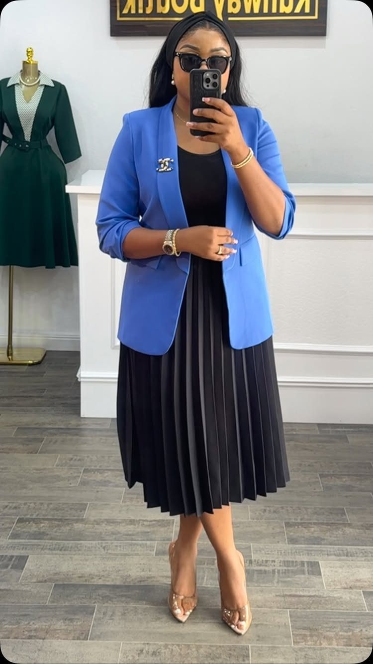 Blue Blazer Outfit for Women: 24 Ideas to Wear 8 Woman wearing a bright blue blazer over a black pleated midi dress and heels.