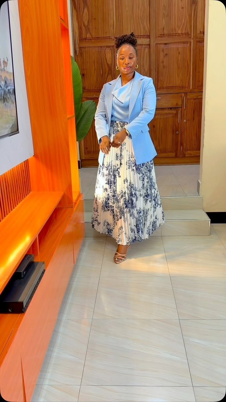 Blue Blazer Outfit for Women: 24 Ideas to Wear 10 Woman wearing a light blue blazer and a blue floral print midi skirt.