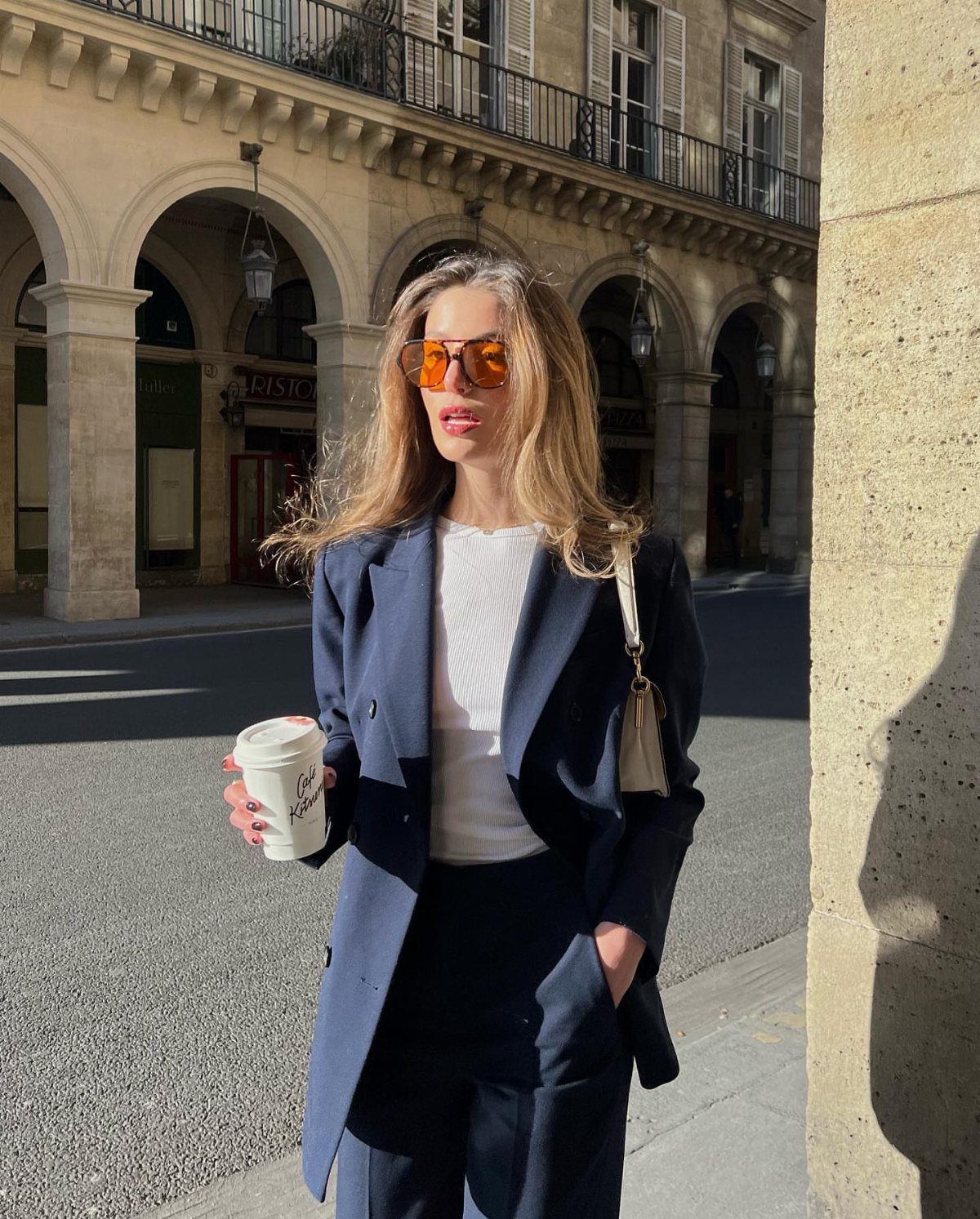 Blue Blazer Outfit for Women: 24 Ideas to Wear 16 Woman in navy blue blazer and trousers holding coffee on a city street