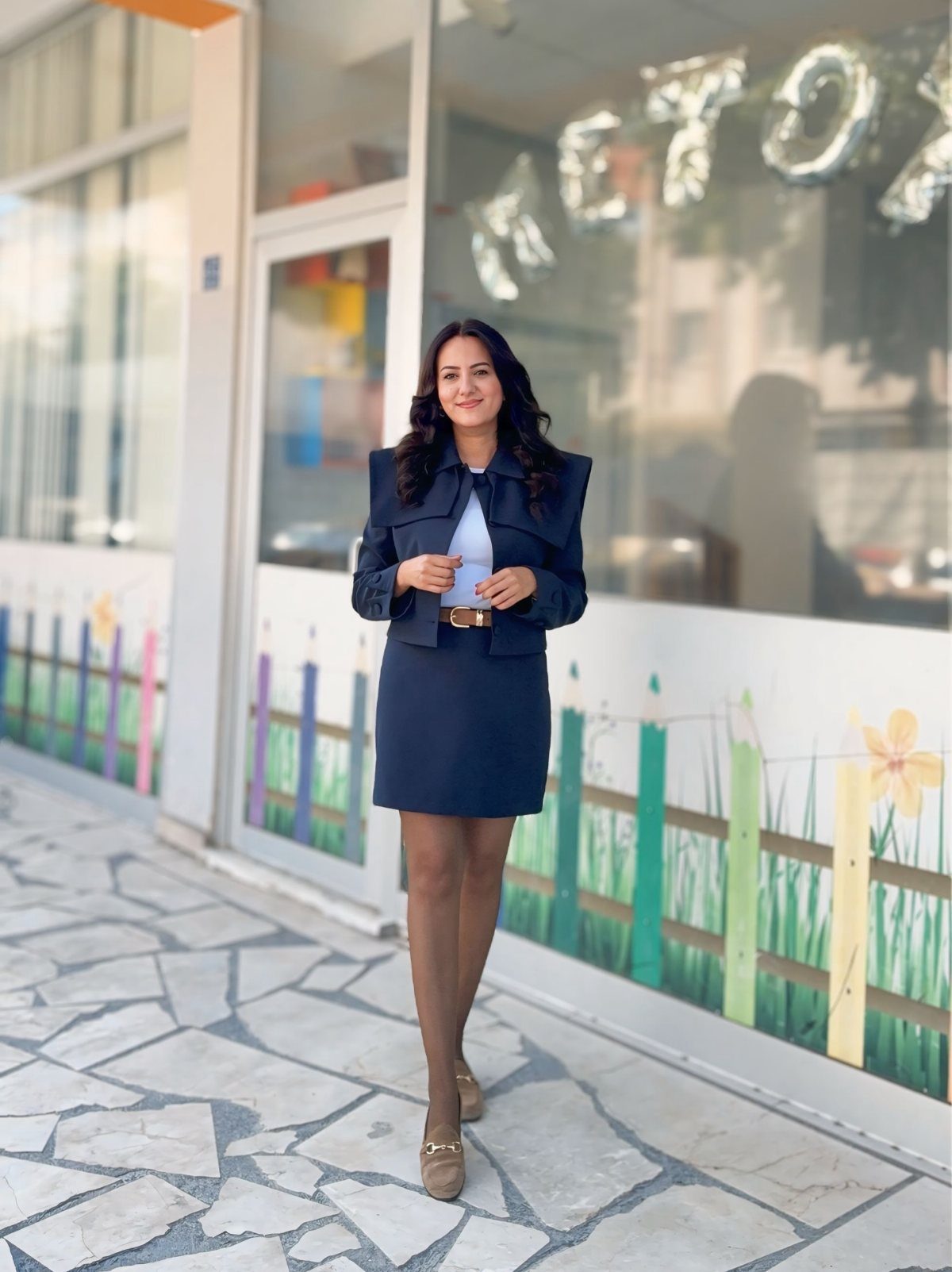 Blue Blazer Outfit for Women: 24 Ideas to Wear 13 Woman wearing a navy blue blazer and matching pencil skirt standing on stone pavement.