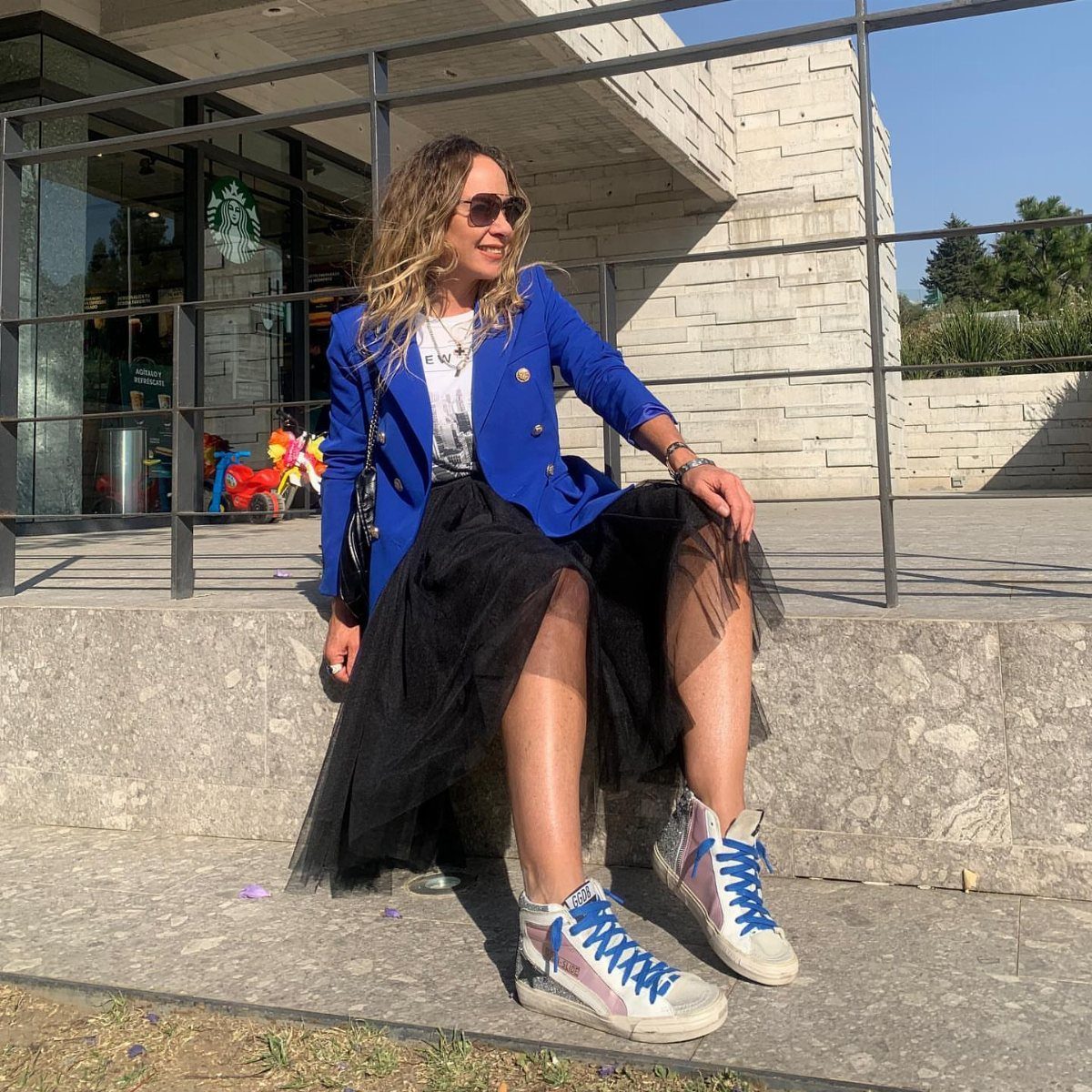 Blue Blazer Outfit for Women: 24 Ideas to Wear 4 Woman wearing a bright blue blazer and black tulle skirt with high-top sneakers.