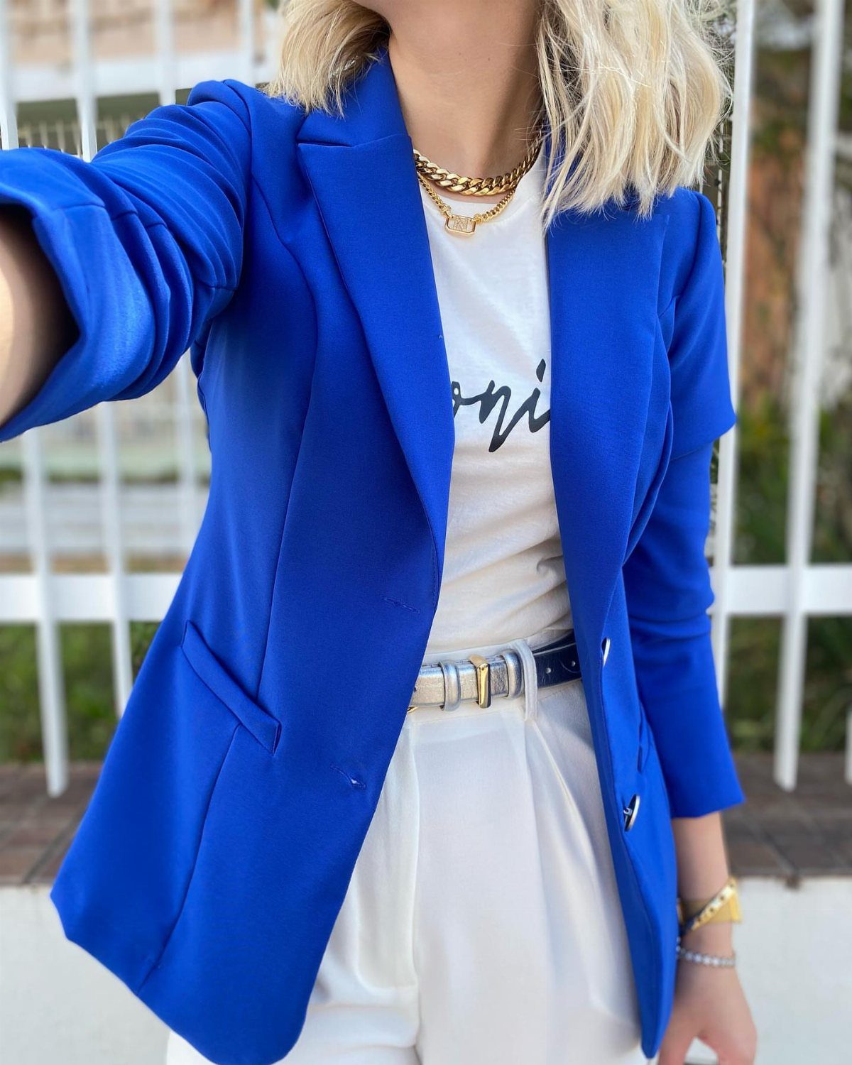 Blue Blazer Outfit for Women: 24 Ideas to Wear 20 Woman wearing a royal blue blazer with a white t-shirt and white trousers.
