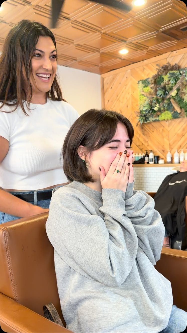 18 Bobo Hair Style Ideas, From Lob to Boxy Cuts 11 Woman with a brown bob and bangs sitting in a hair salon chair.