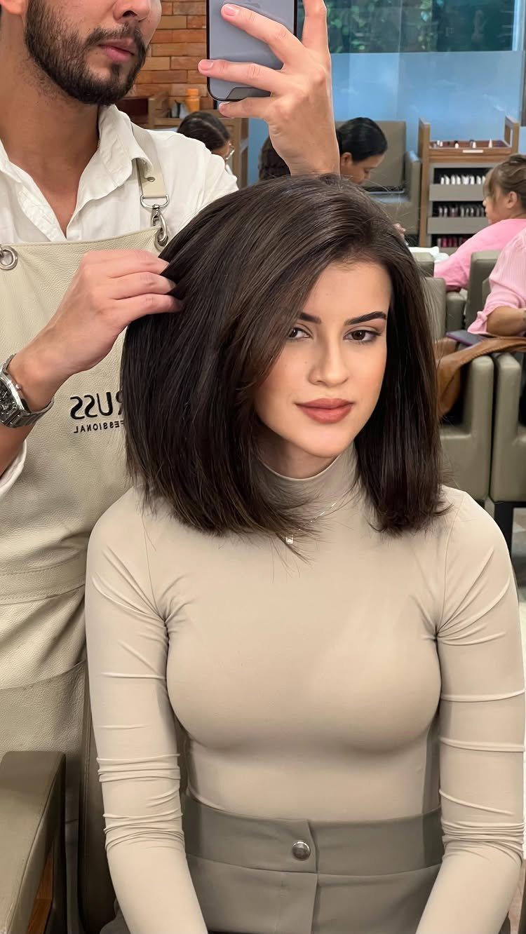 18 Bobo Hair Style Ideas, From Lob to Boxy Cuts 1 Woman with a sleek dark brown long bob haircut in a hair salon