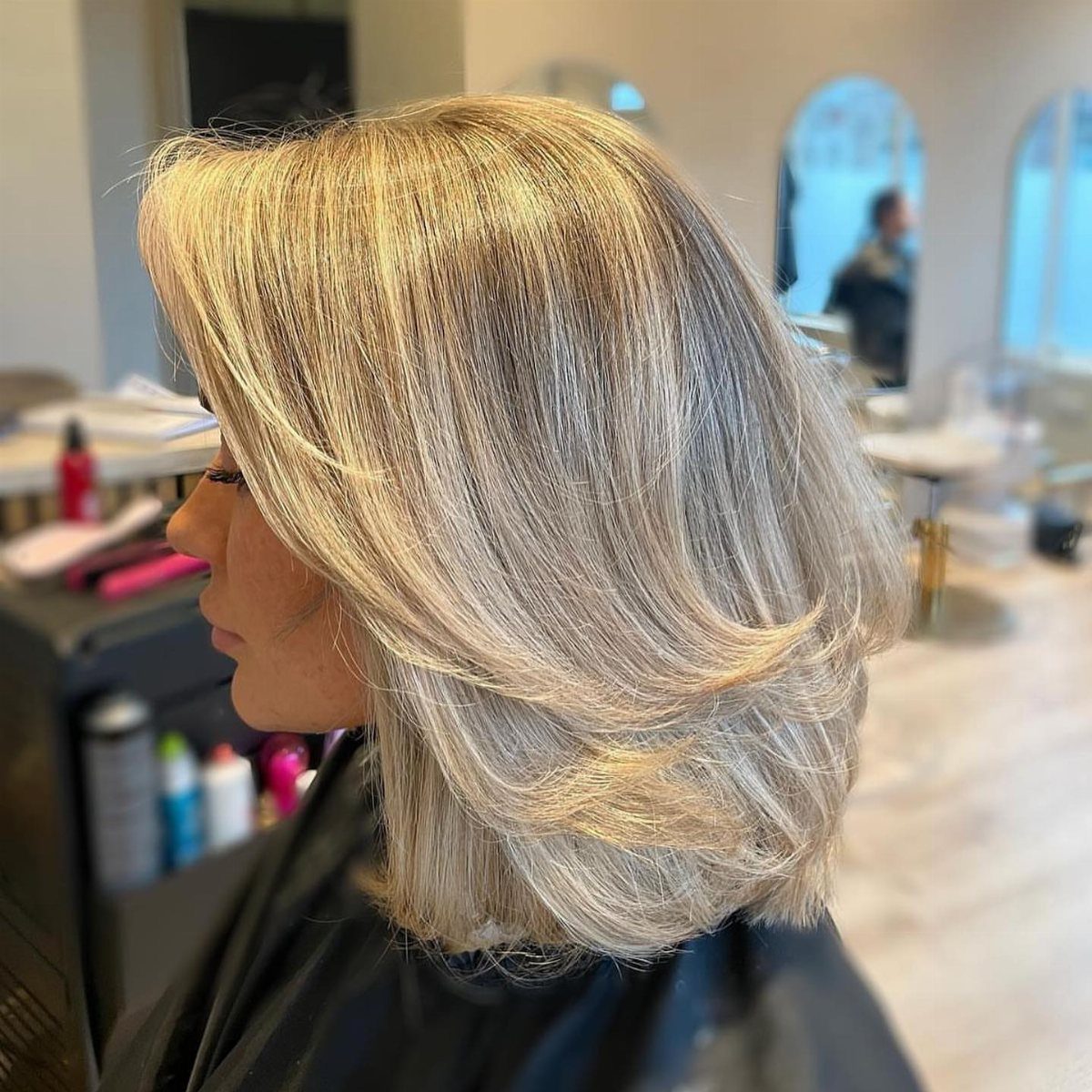 18 Bobo Hair Style Ideas, From Lob to Boxy Cuts 16 Woman with a voluminous, glossy blonde layered bob haircut in a hair salon.