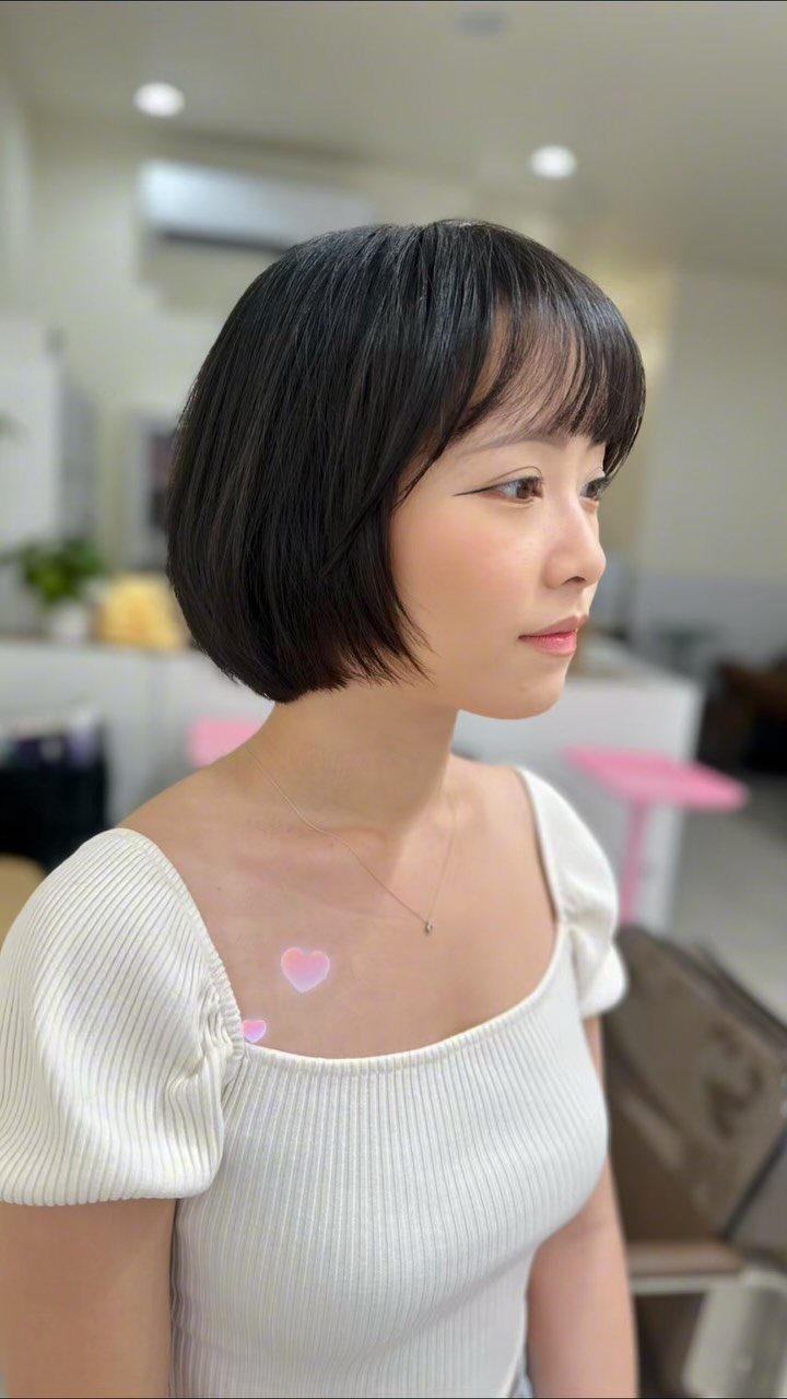 18 Bobo Hair Style Ideas, From Lob to Boxy Cuts 10 Woman with a dark rounded bob haircut and bangs in a salon.