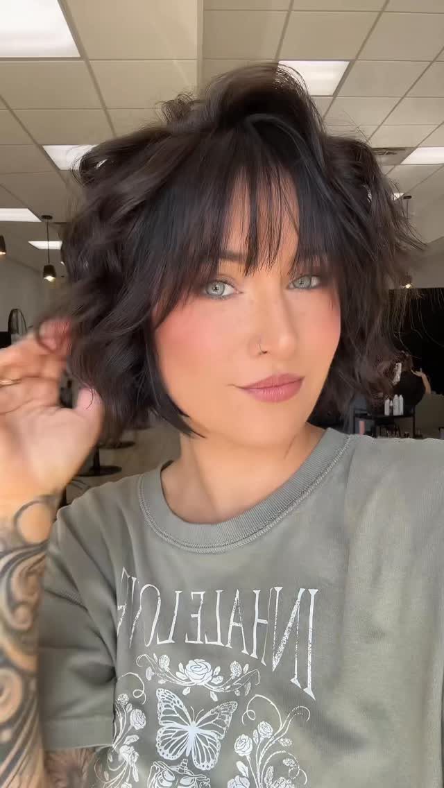 18 Bobo Hair Style Ideas, From Lob to Boxy Cuts 12 Woman with a dark brown wavy bob haircut and bangs wearing olive green shirt