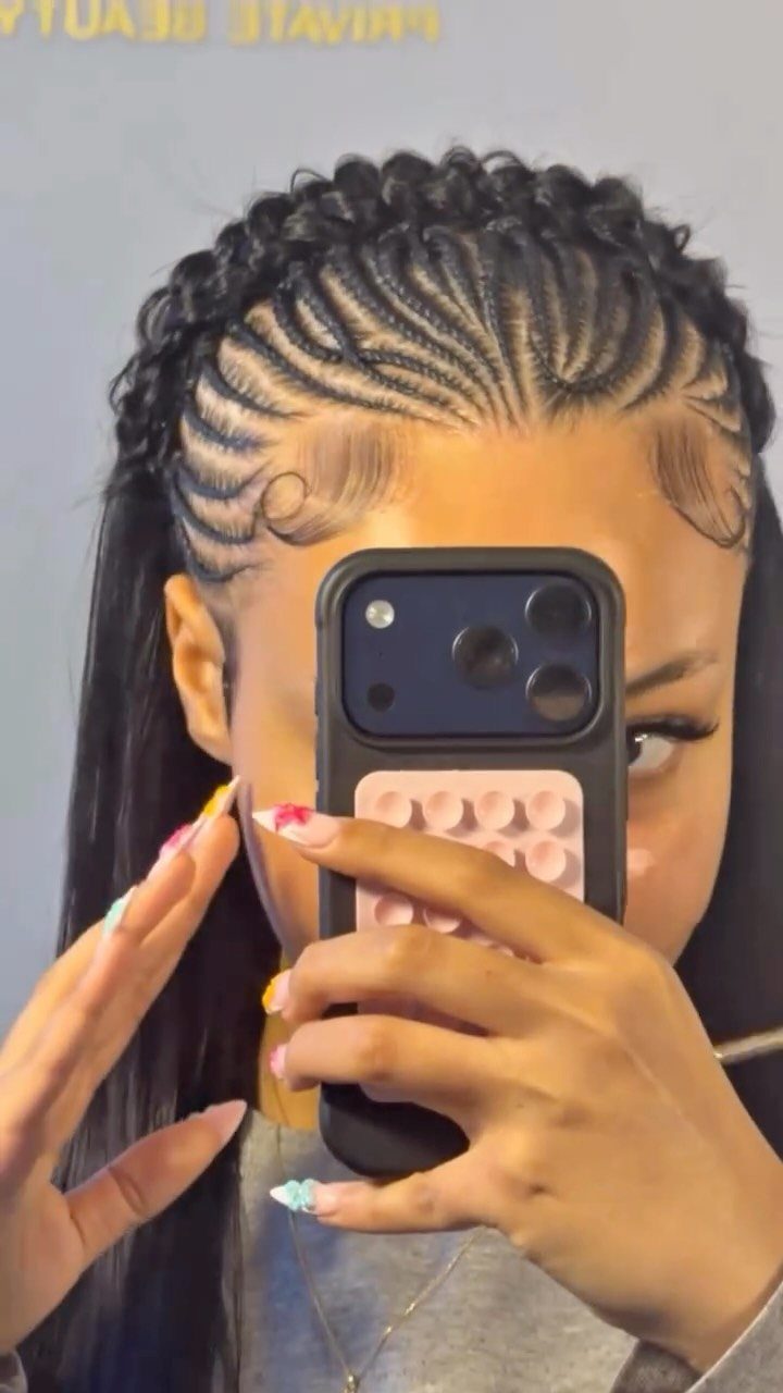 27 Boho Fulani Braids Hairstyles for Every Length and Look 18 Woman with Fulani braids styled into a crown shape taking a mirror selfie.