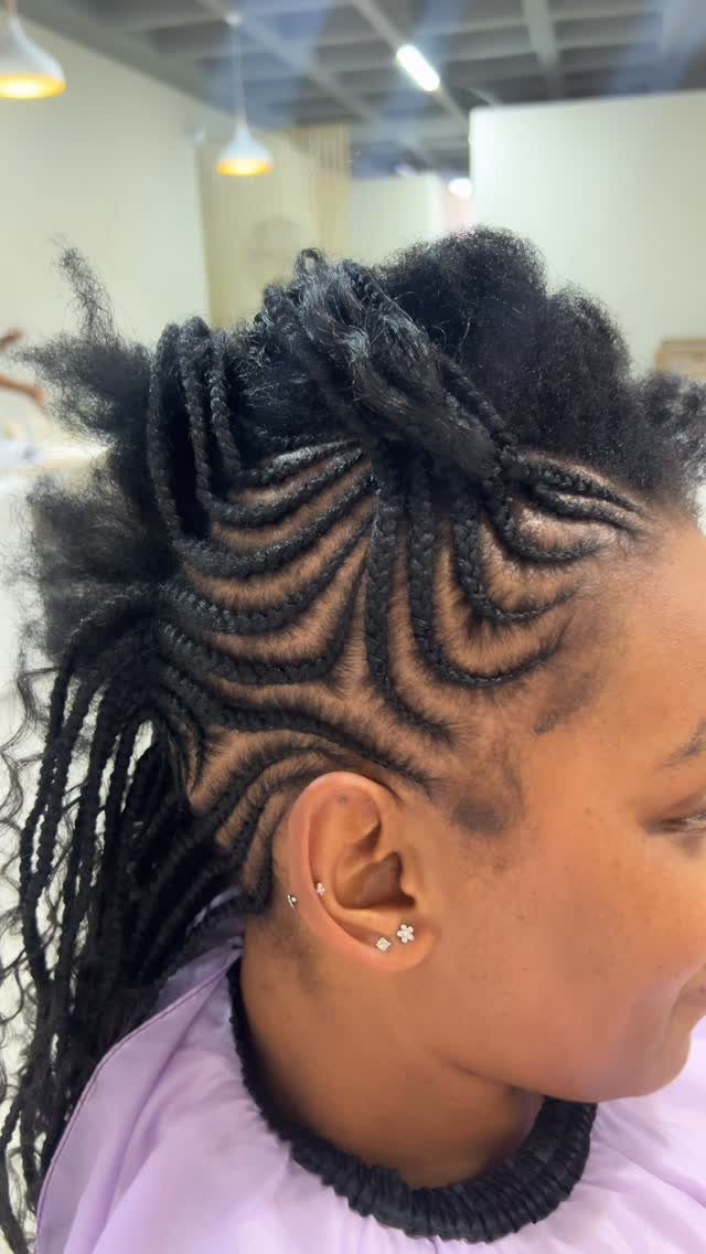 27 Boho Fulani Braids Hairstyles for Every Length and Look 22 Woman with black Fulani braids styled into a bold mohawk with curly textures.