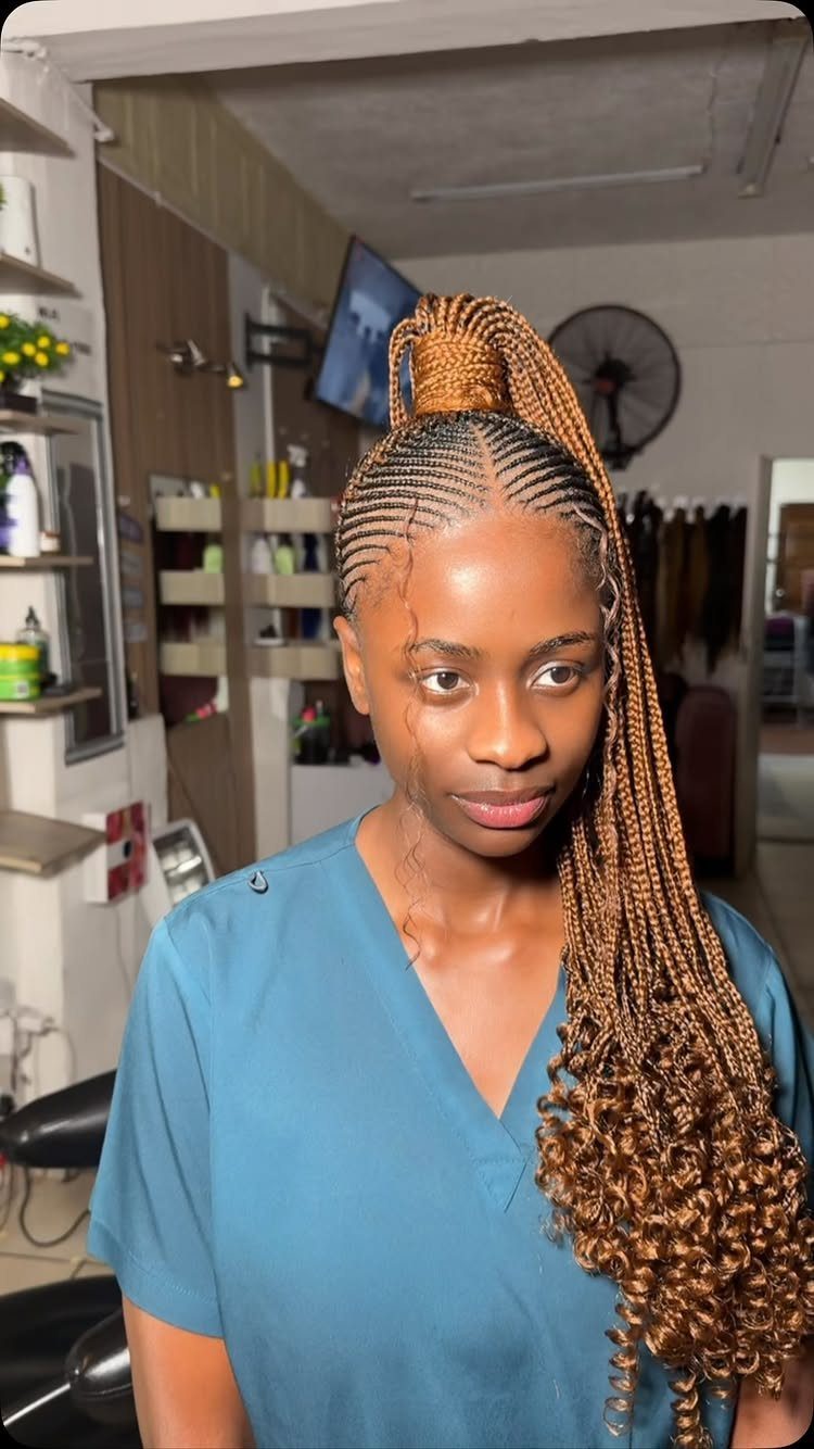 27 Boho Fulani Braids Hairstyles for Every Length and Look 5 Woman with brown Fulani braids tied into a high ponytail with curly ends.