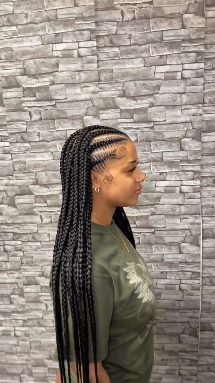 27 Boho Fulani Braids Hairstyles for Every Length and Look 19 Woman with thick jumbo Fulani braids and cornrows against a stone wall background