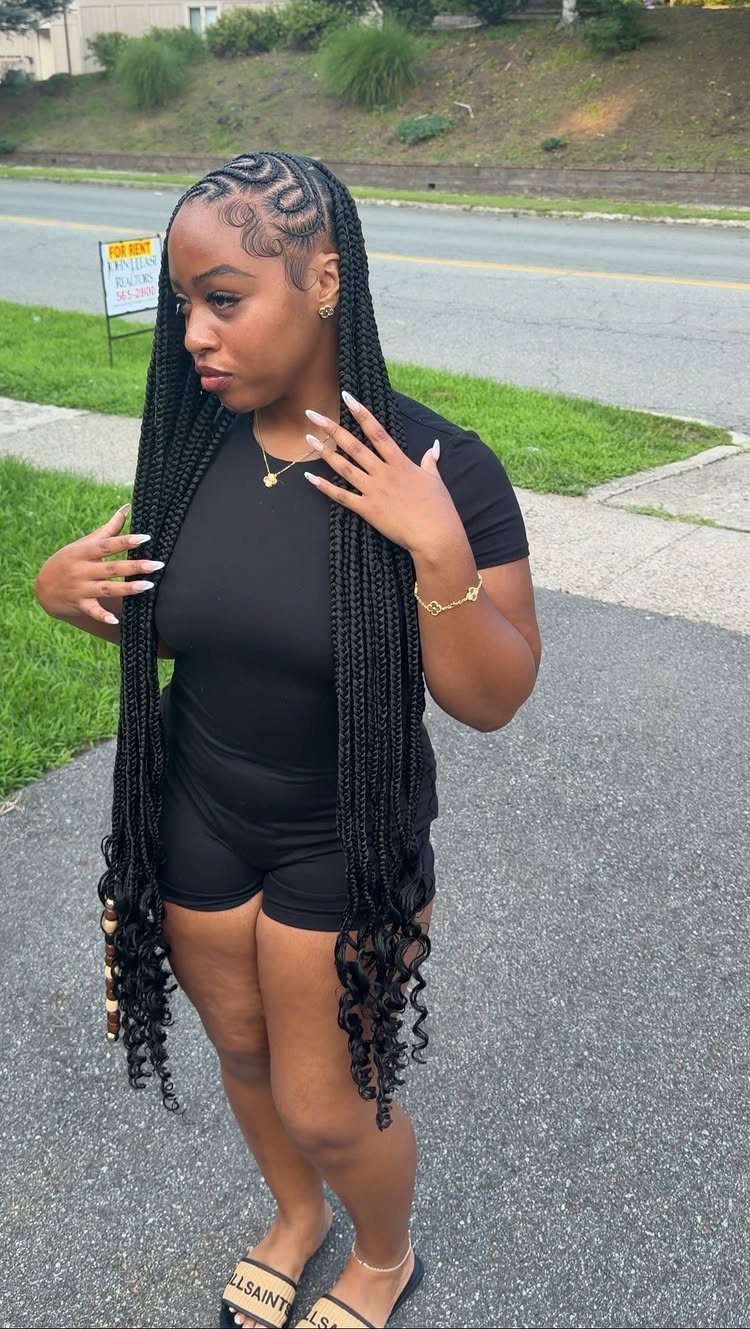 27 Boho Fulani Braids Hairstyles for Every Length and Look 8 Woman with long black Fulani braids and curly ends wearing a black romper.