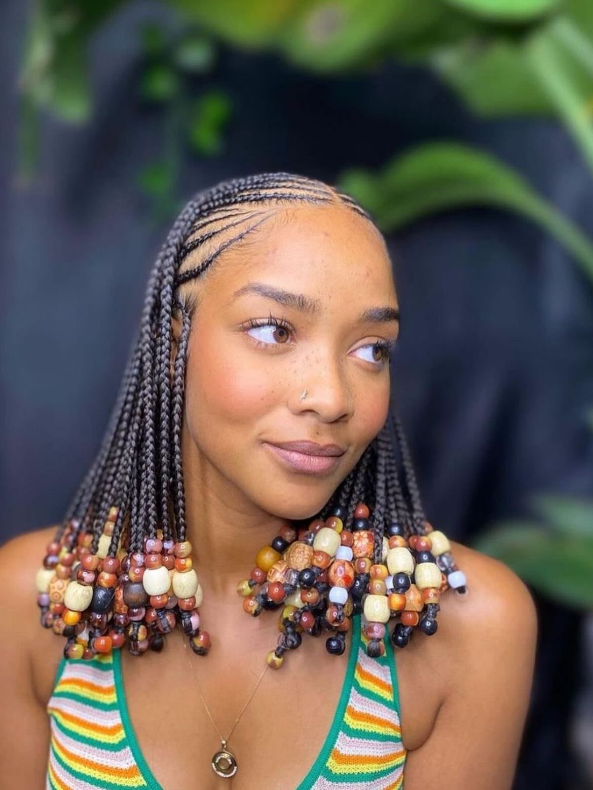 27 Boho Fulani Braids Hairstyles for Every Length and Look 6 Woman with short Fulani braids decorated with colorful beads at the ends.
