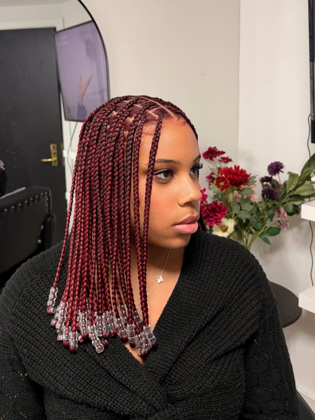 Woman with burgundy jumbo box braids and clear beads at the ends
