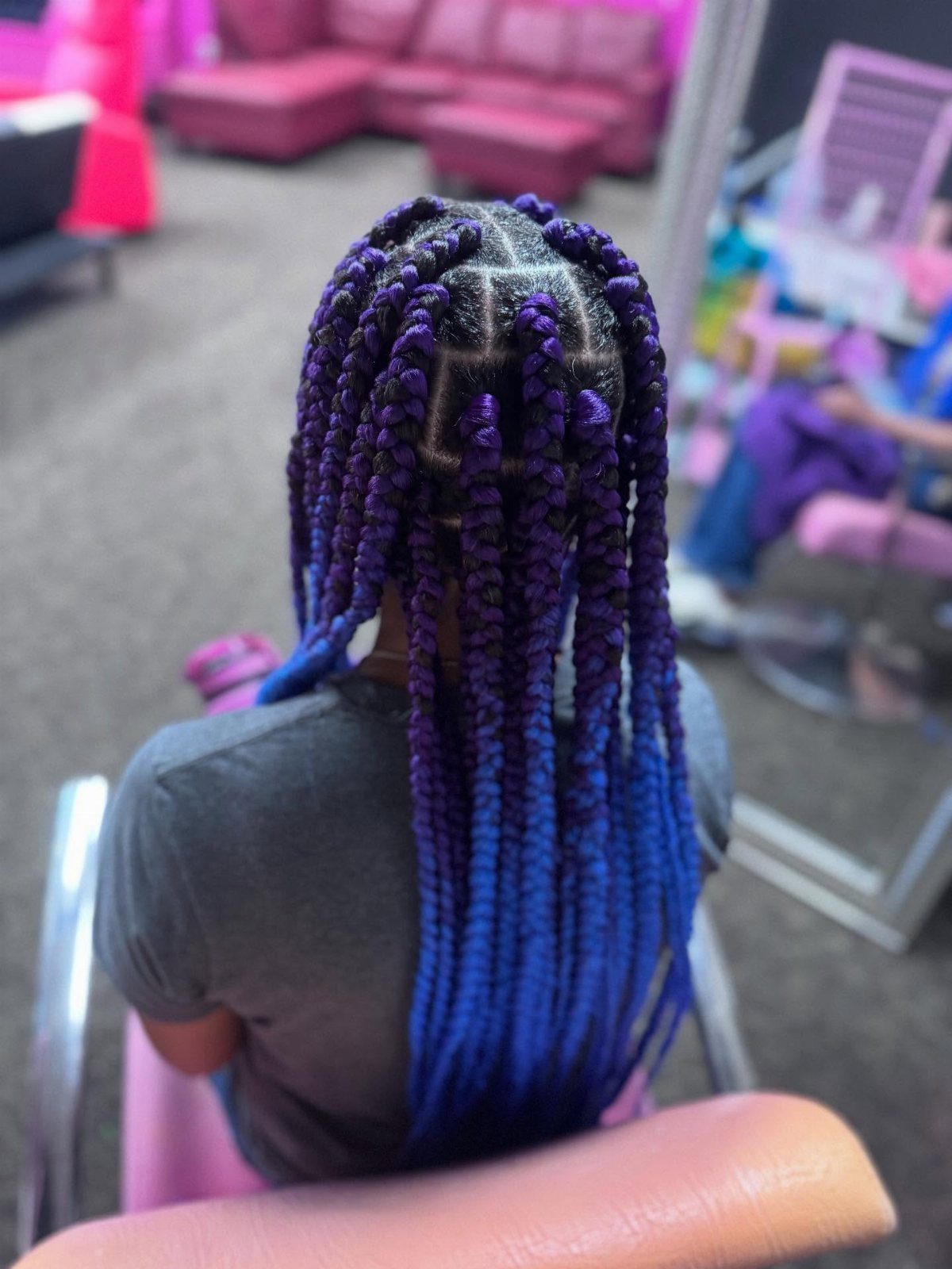 Long box braids transitioning from deep purple to bright blue on a person.