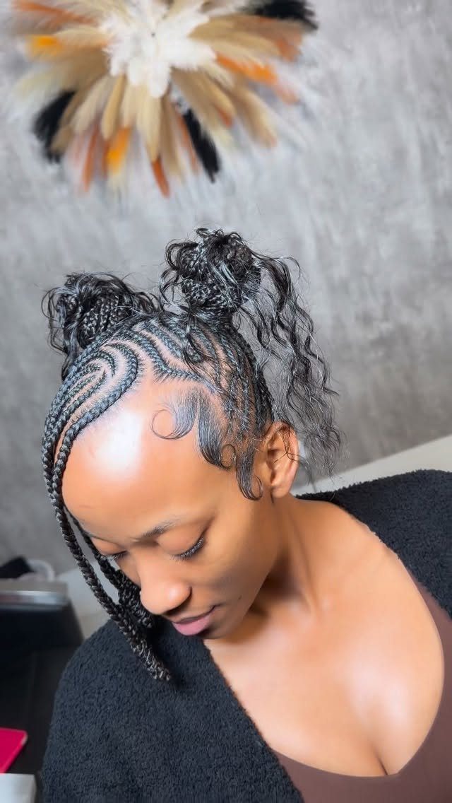 Woman with black braided hair styled into two space buns and cornrows.